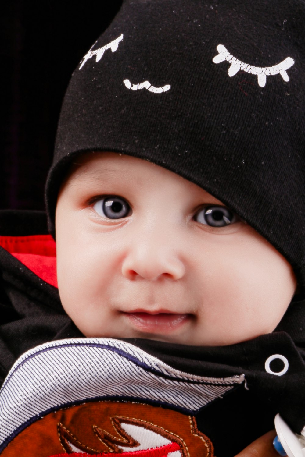a baby wearing a black hat and scarf