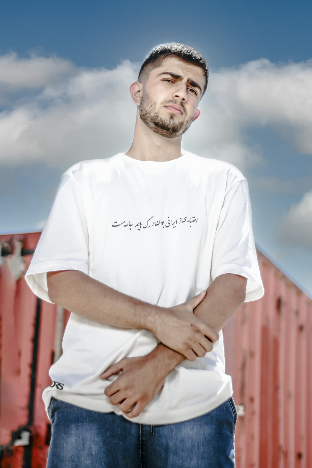 a man standing with his arms crossed in front of a train