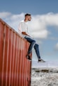 a man sitting on top of a red wall
