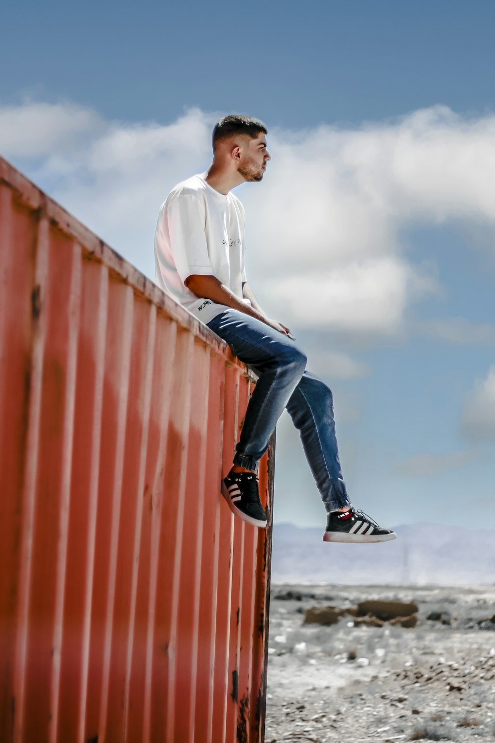 a man sitting on top of a red wall
