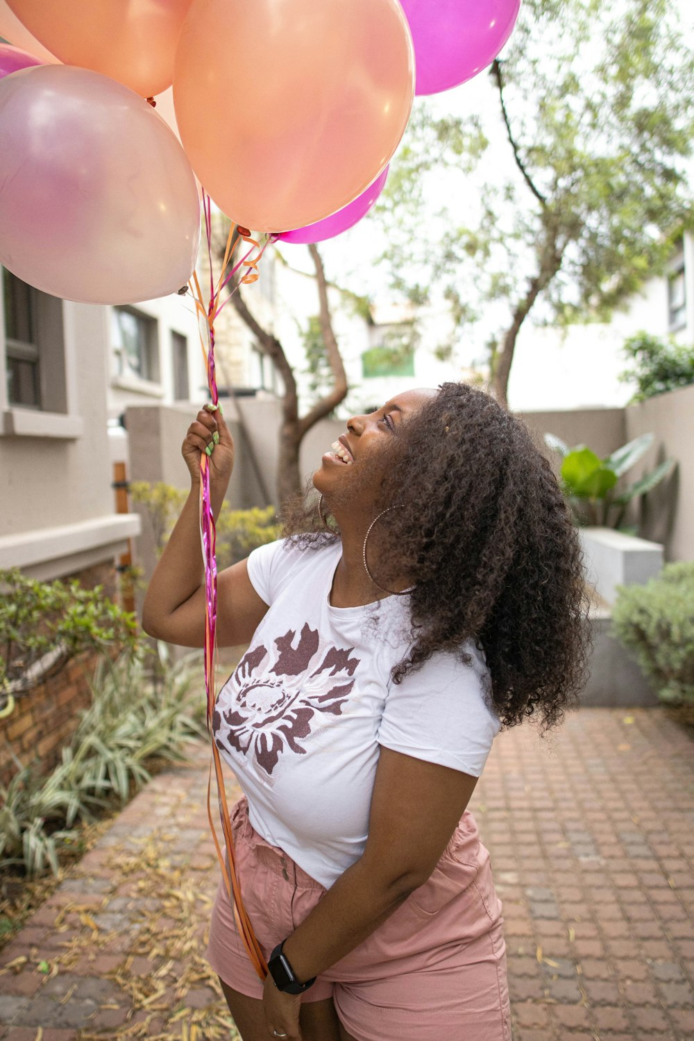 a woman holding a bunch of balloons in her hand