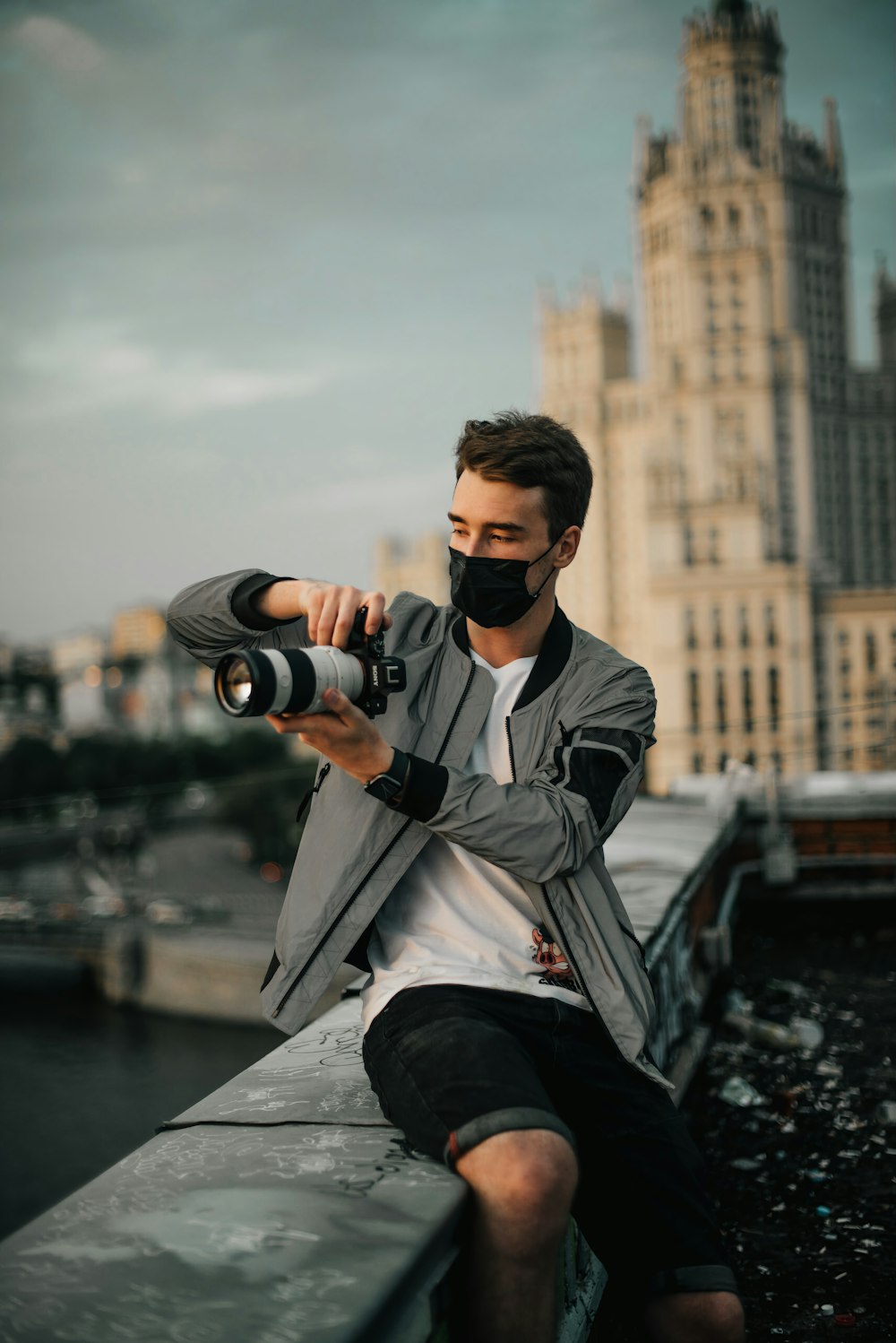 a man sitting on a ledge with a camera