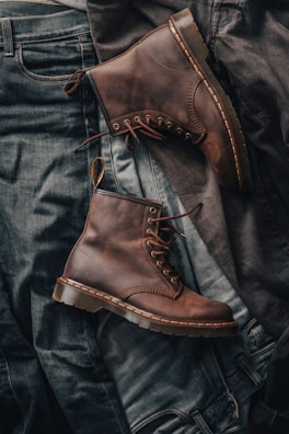 Stylish boots for men displayed against a rustic background.