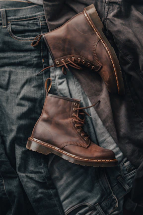 Close-up of stylish men's leather boots paired with dark denim jeans.