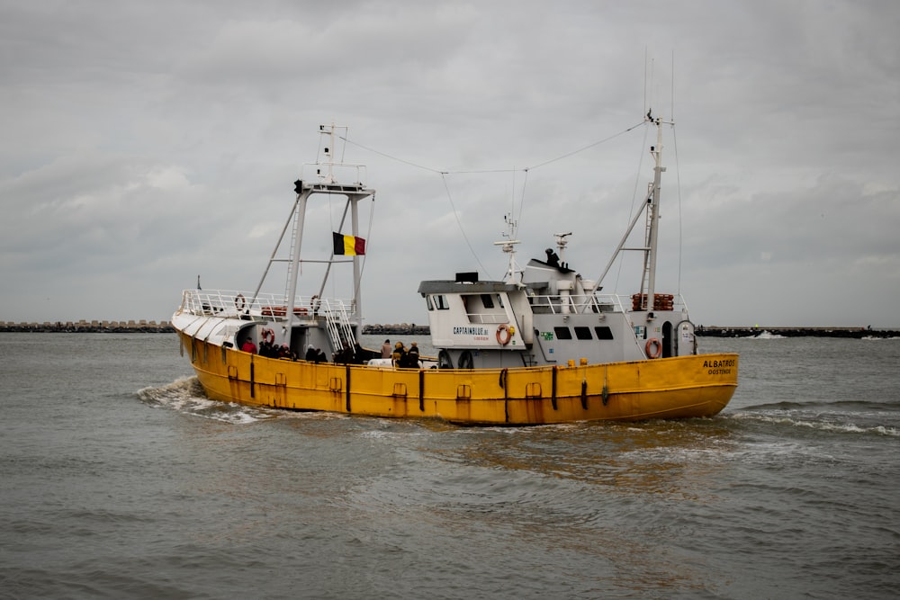 a large yellow boat traveling across a body of water