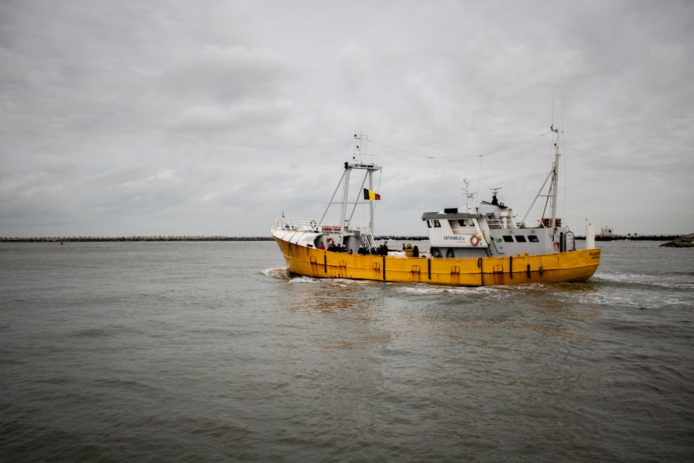 a large yellow boat traveling across a large body of water