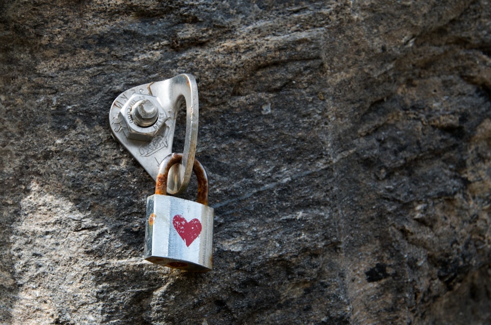 a padlock attached to a rock with a heart on it