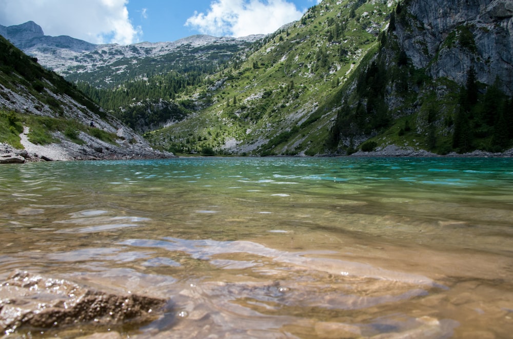 a mountain lake surrounded by green mountains under a blue sky