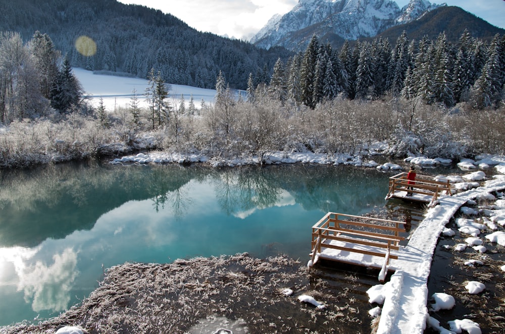 a person sitting on a bench next to a body of water