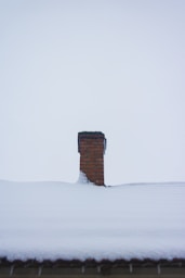 a chimney in the middle of a snow covered roof