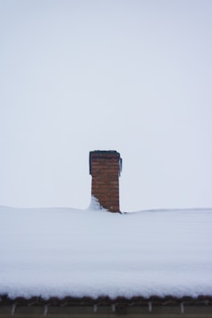 a chimney in the middle of a snow covered roof