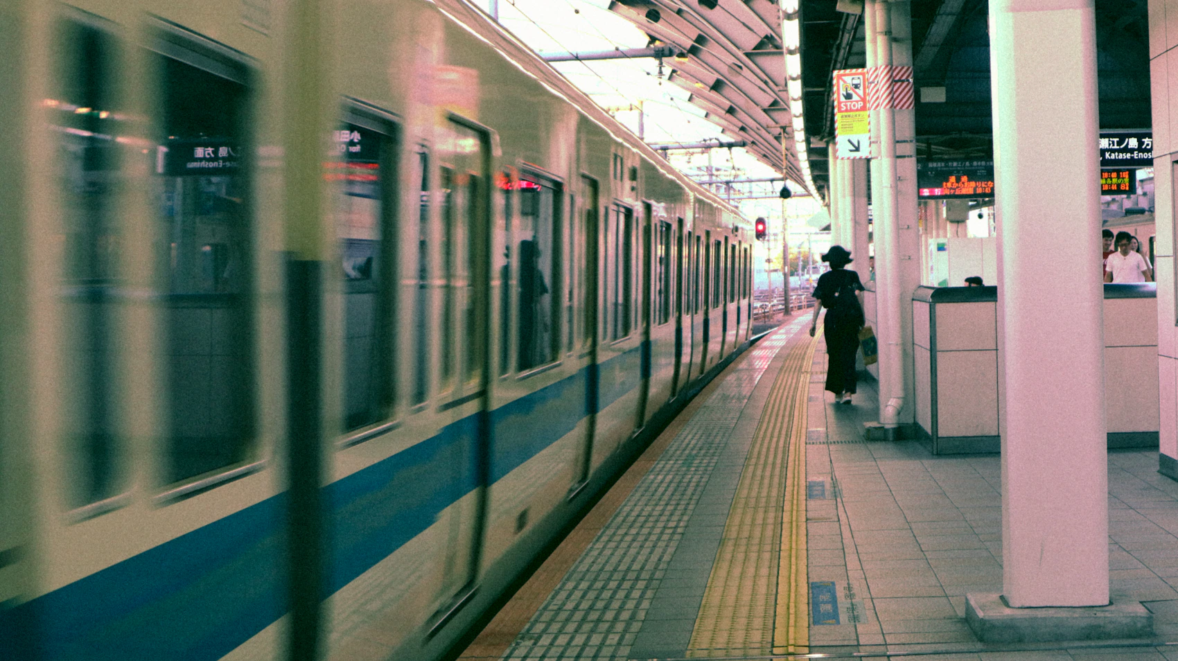 A train arriving beside waiting passengers at Tokyo Station