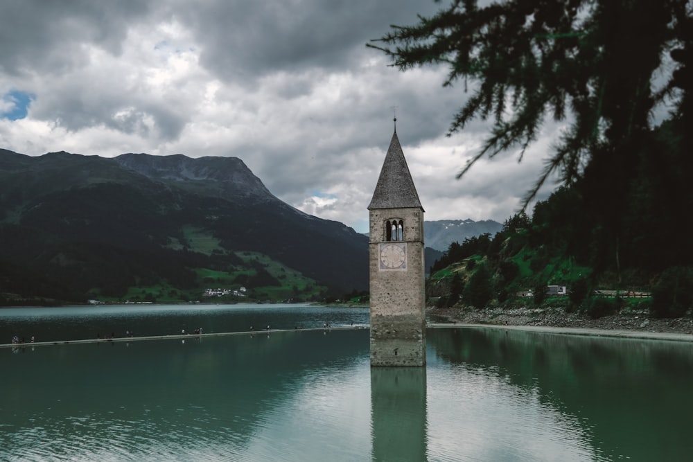 a clock tower sitting in the middle of a lake