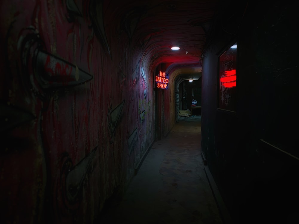 a dark hallway with graffiti on the walls