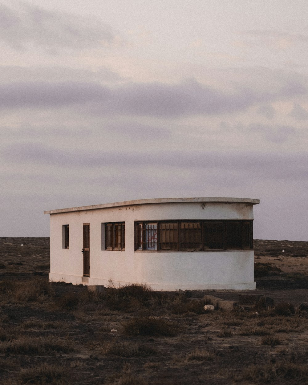 a white building sitting in the middle of a field