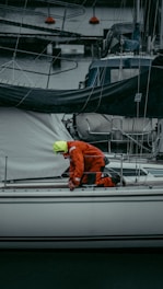 A professional technician inspecting a yacht hull at a marina dock.