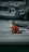 A person in a bright orange and yellow rain suit is kneeling on a white sailboat at a marina, surrounded by other boats and dock lines. The person appears to be adjusting or checking something on the deck.