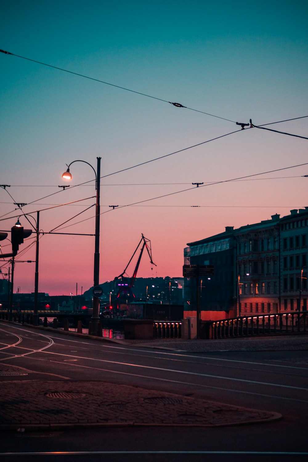 a city street at dusk with a street light in the foreground