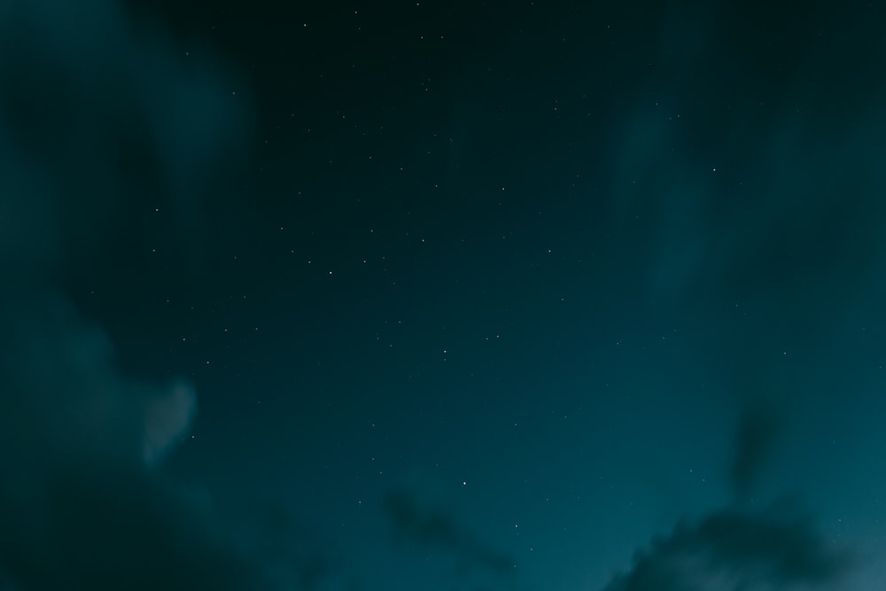 a night sky with a few clouds and stars