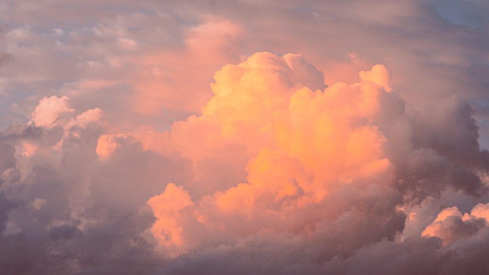 a plane flying through a cloud filled sky