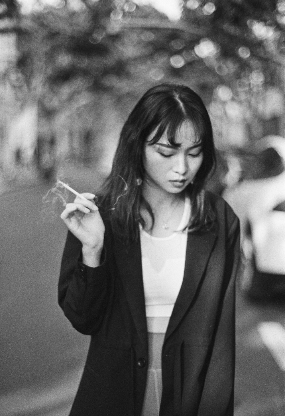 a woman smoking a cigarette on a city street