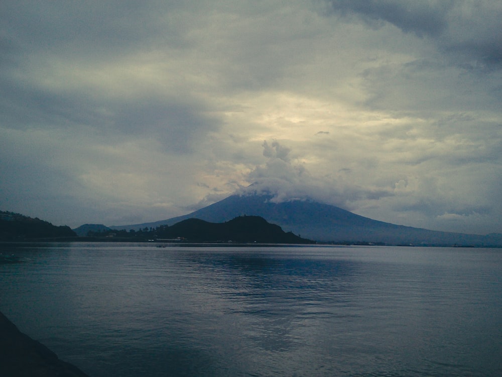 a large body of water with a mountain in the background