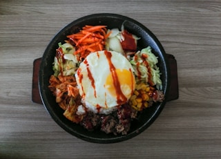 a bowl of food with an egg on top of it