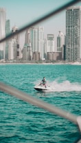 A vibrant jet ski speeding over the turquoise waters of Cancun with white sandy beaches in the background.
