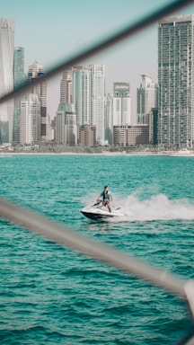 A vibrant jet ski speeding over the turquoise waters of Cancun with white sandy beaches in the background.