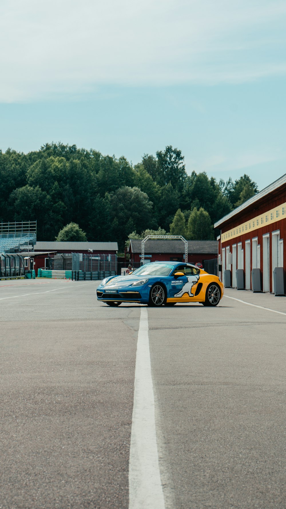 a blue and yellow sports car parked in a parking lot