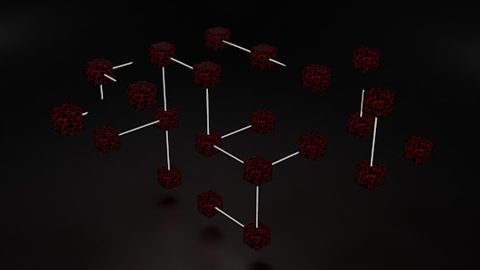 Clusters of interconnected cubes with a dark, web-like texture are set against a black background, with some cubes connected by thin white lines.