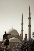 a statue of a man riding a horse in front of a building