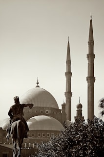 a statue of a man riding a horse in front of a building