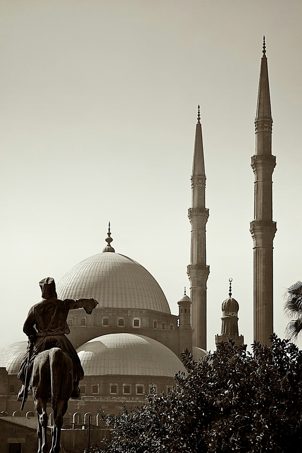 a statue of a man riding a horse in front of a building