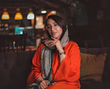 a woman sitting on a couch wearing a scarf