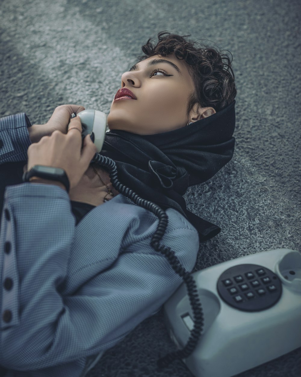 a woman laying on the ground talking on a phone