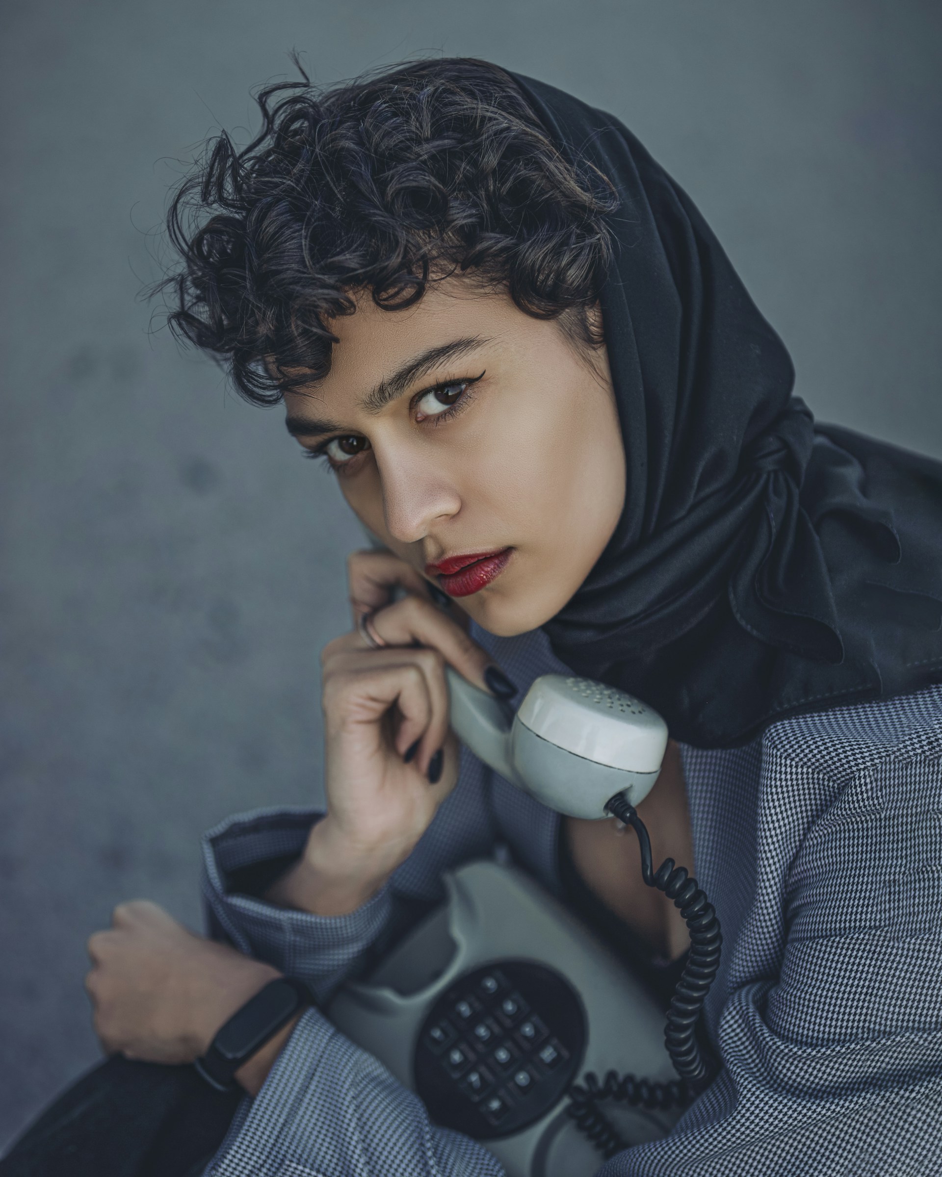 a woman wearing a headscarf and talking on a phone