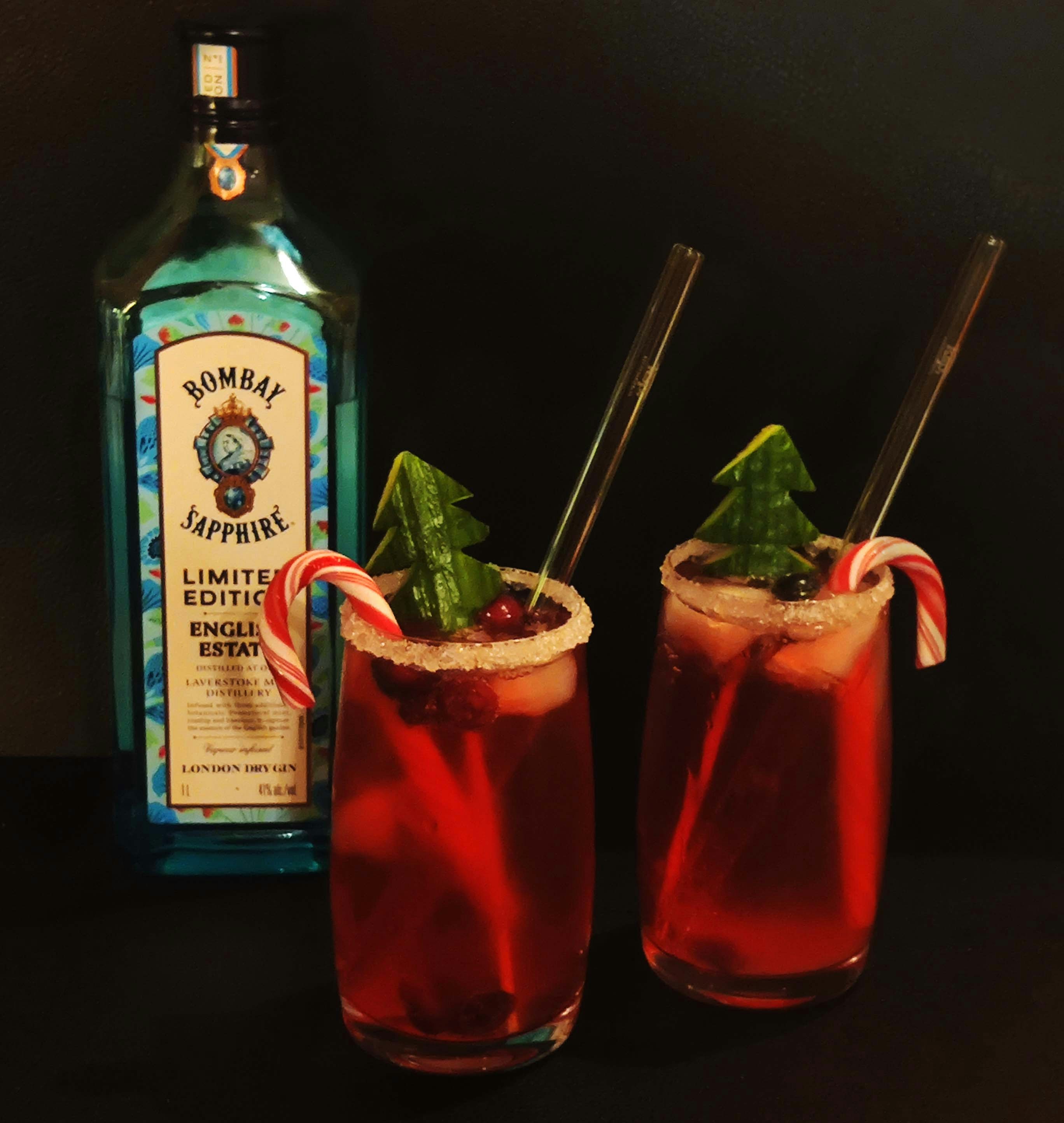 two glasses filled with a drink next to a bottle