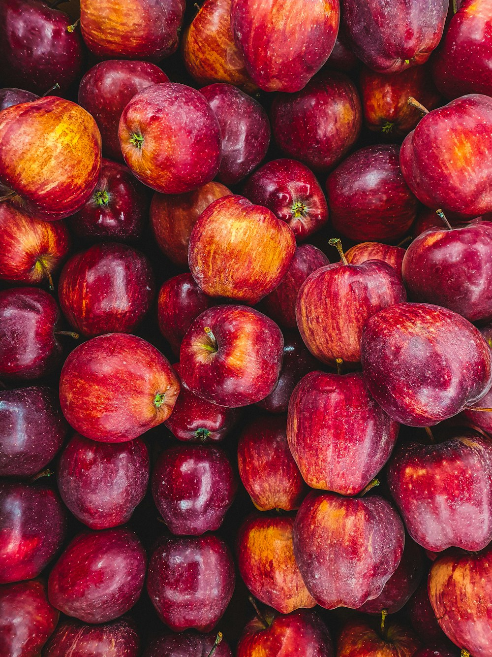 a pile of red apples sitting next to each other