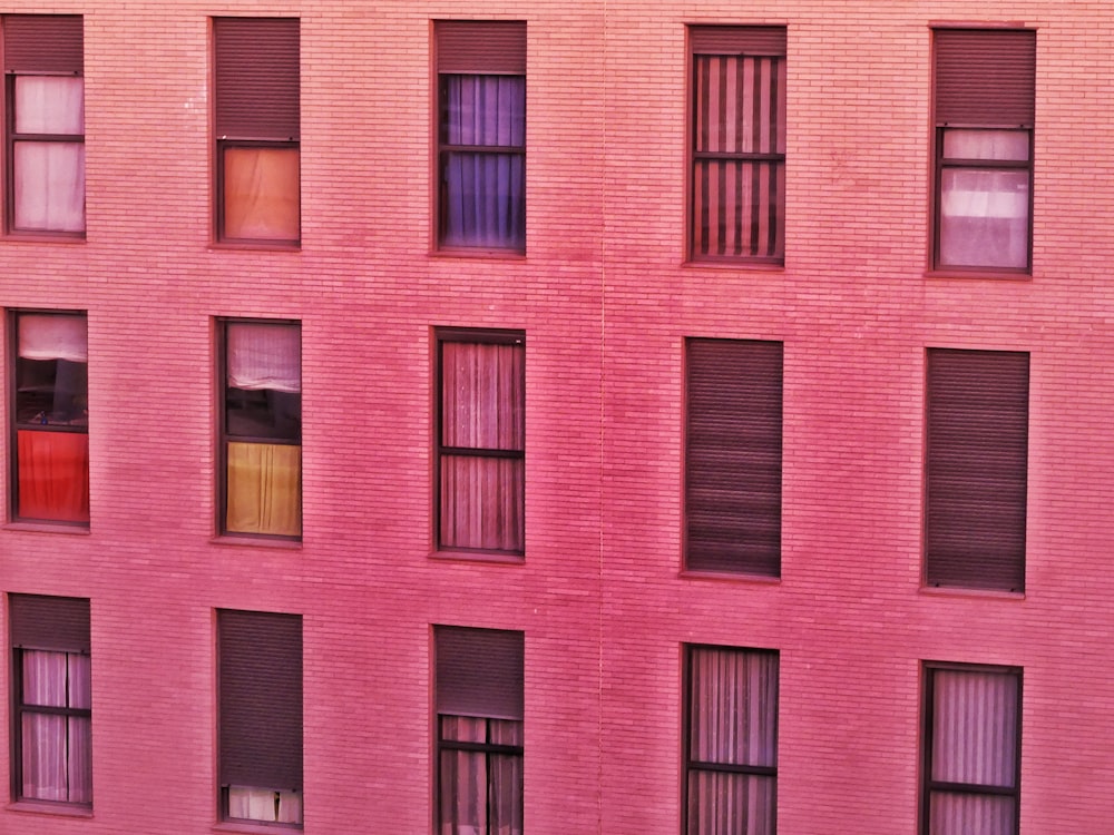 a pink building with many windows and a clock