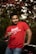 a man in a red shirt holding a wine glass