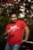 a man in a red shirt holding a wine glass