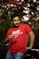 a man in a red shirt holding a wine glass