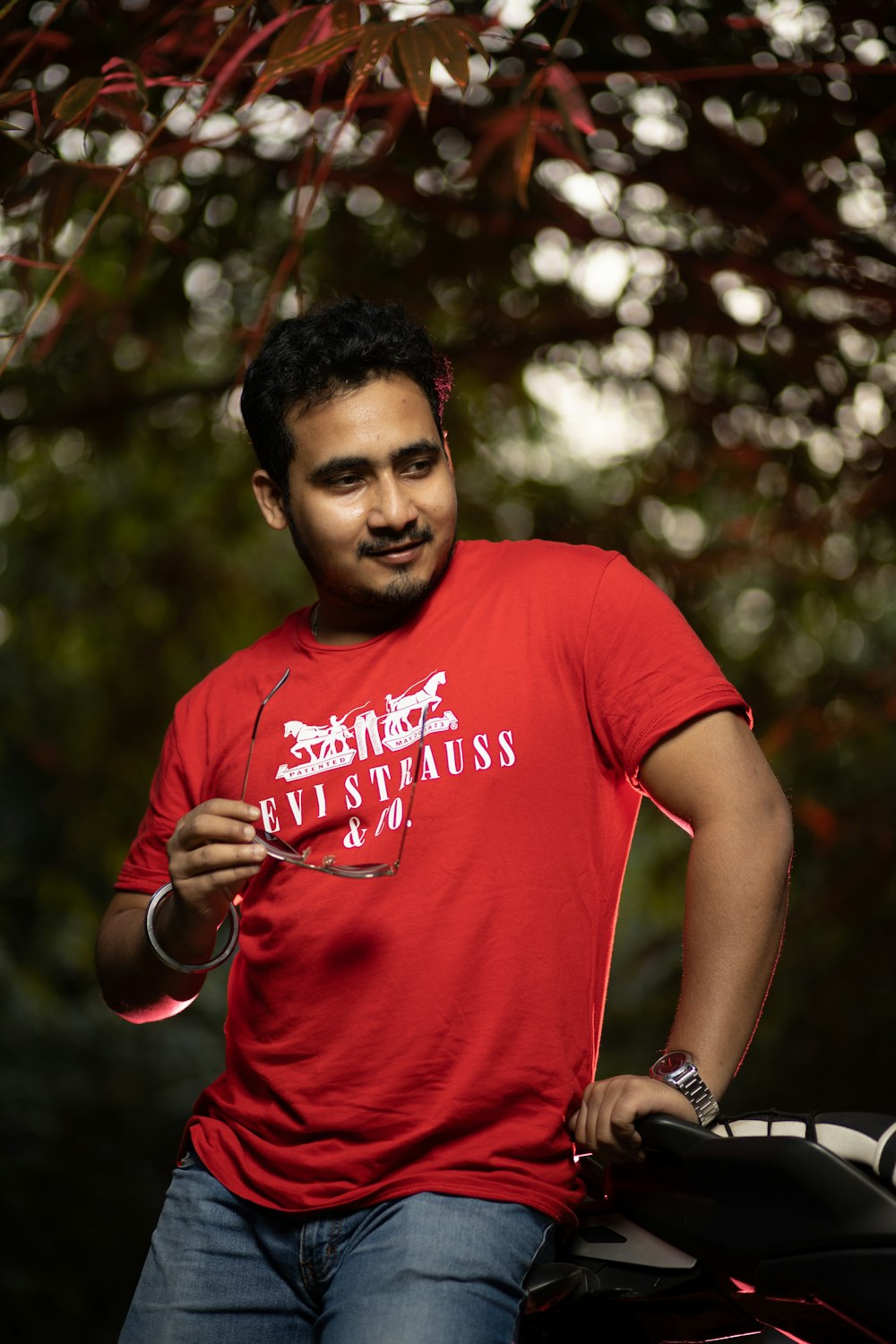 a man in a red shirt holding a wine glass