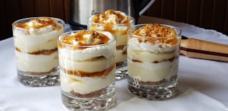 four desserts sitting on a table with a crock pot in the background