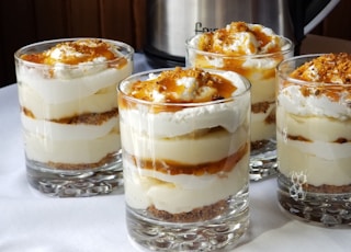 four desserts sitting on a table with a crock pot in the background