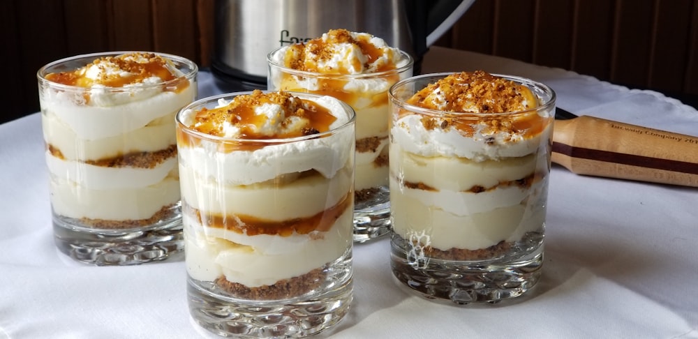 four desserts sitting on a table with a crock pot in the background