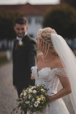 a bride and groom walking down a road