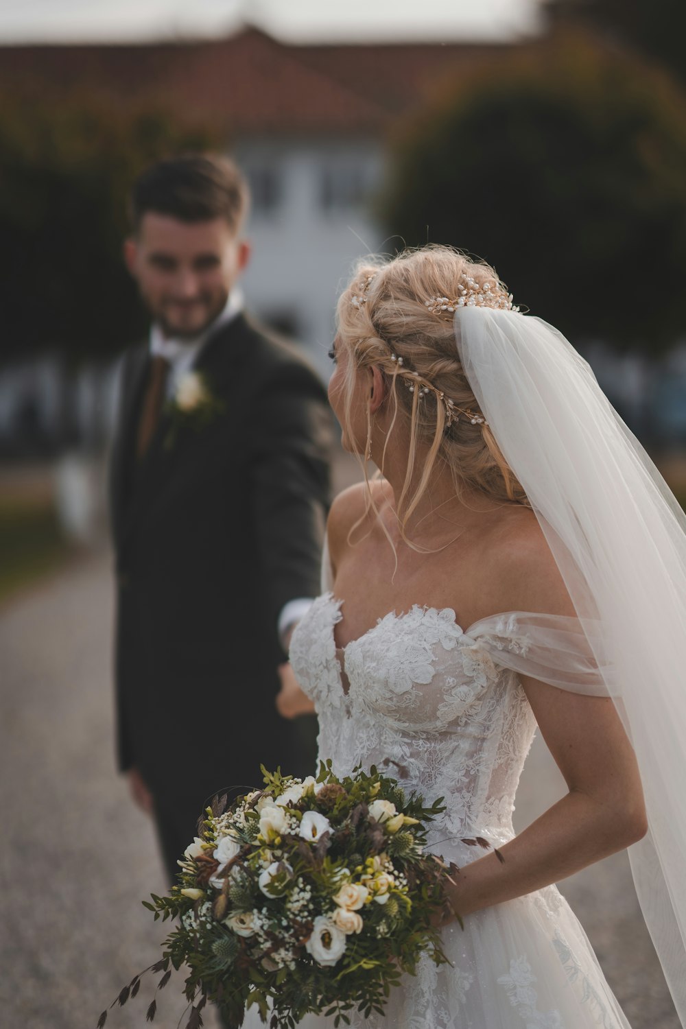 a bride and groom walking down a road