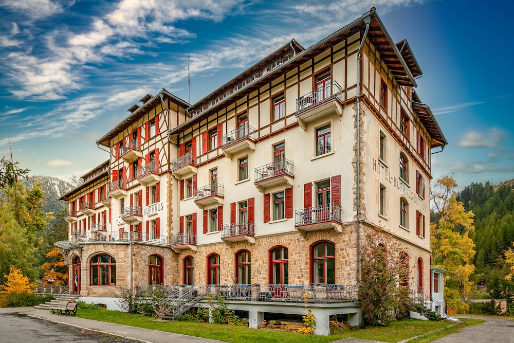 a large white building with red shutters and balconies